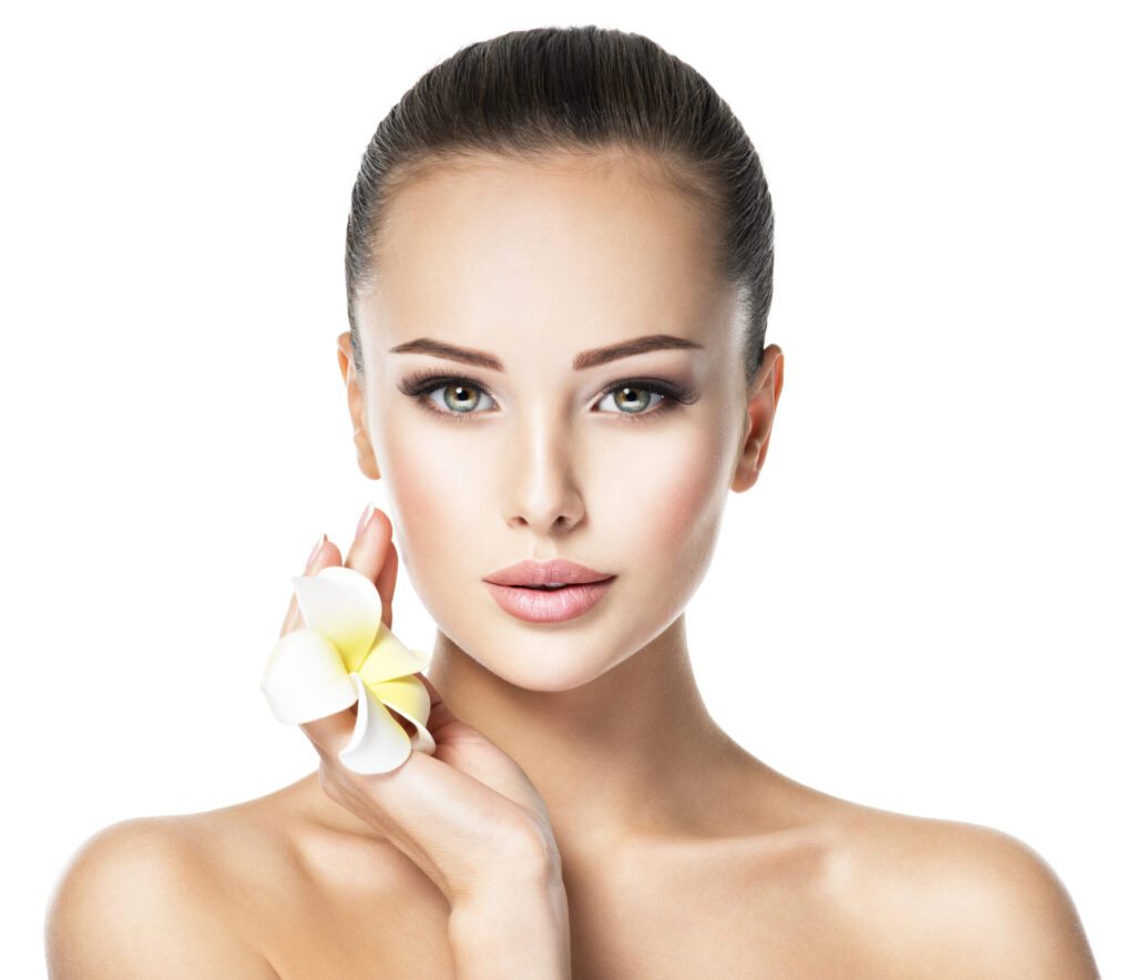 Beautiful face of young woman with flower. Clean healthy skin.