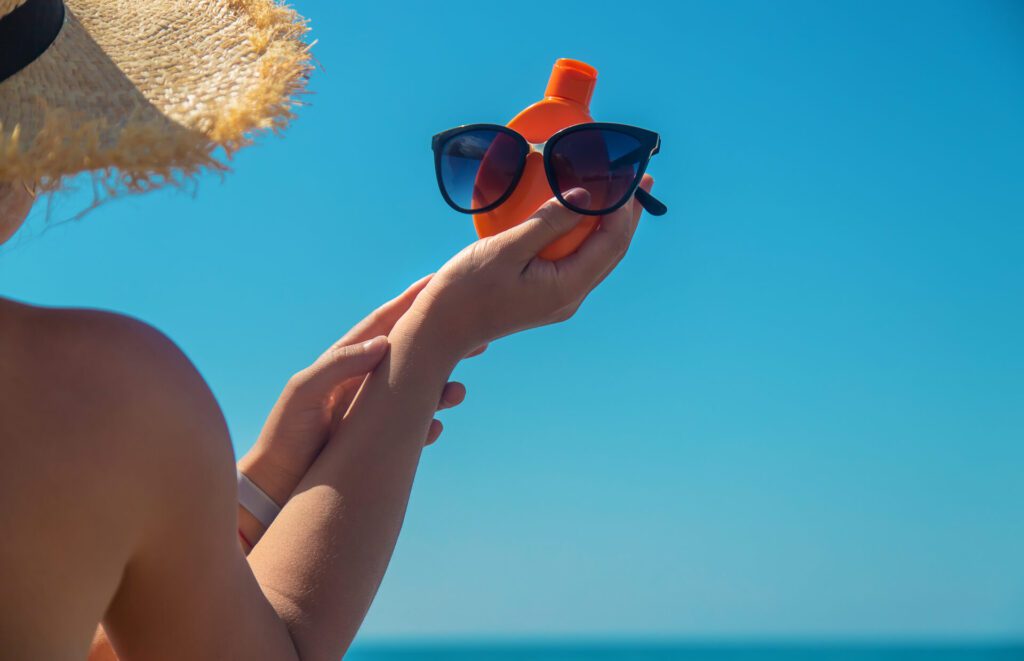 Sunscreen in the hands of a woman. Selective focus. Nature.